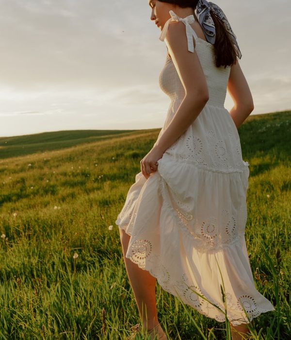Woman performing a gentle, flowing movement in a bright, calm room.
